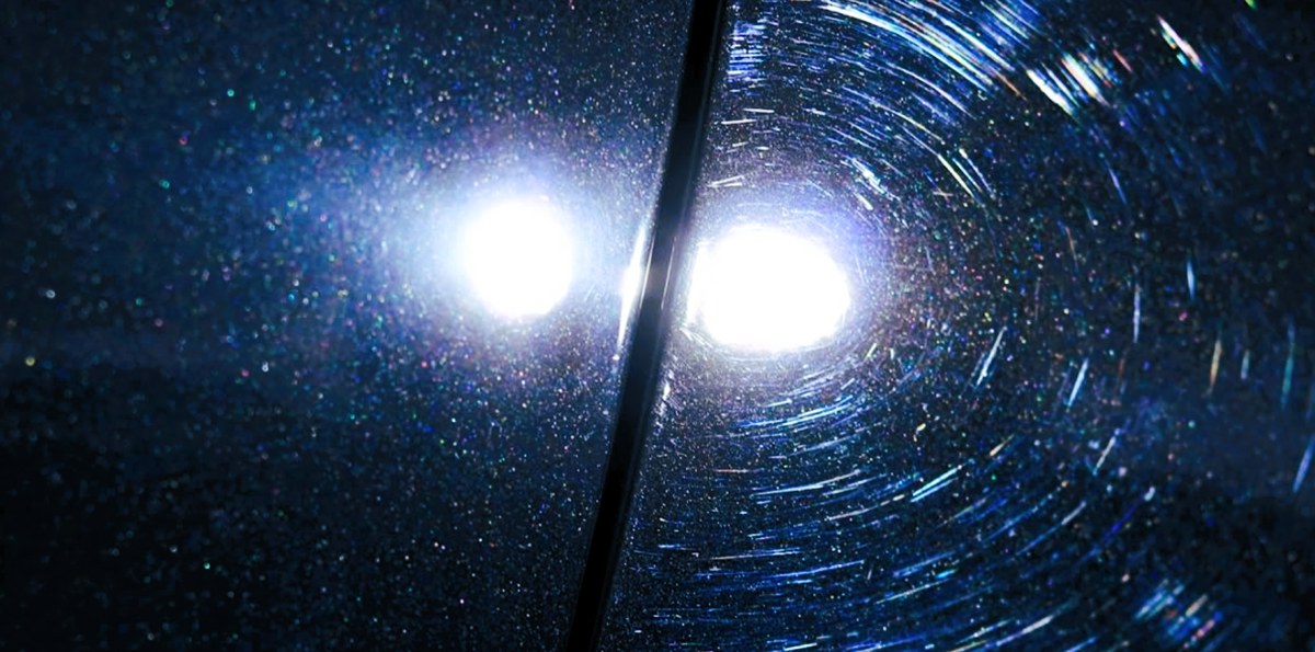 Swirl marks visible on dark car paint under bright light